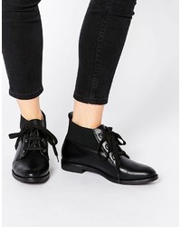 schwarze flache Stiefel mit einer Schnürung aus Leder