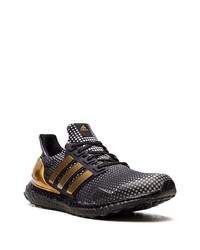 schwarze und goldene Sportschuhe von adidas