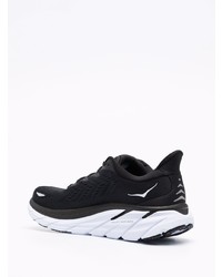 schwarze und weiße Sportschuhe von Hoka One One