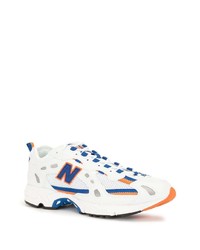 weiße und blaue Sportschuhe von New Balance