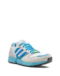 weiße und blaue Sportschuhe von adidas