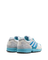 weiße und blaue Sportschuhe von adidas