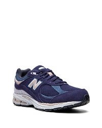 weiße und dunkelblaue Sportschuhe von New Balance