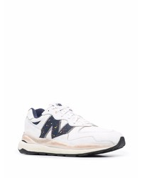 weiße und dunkelblaue Sportschuhe von New Balance