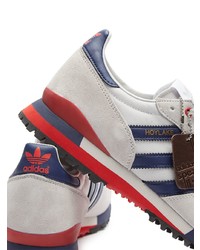 weiße und dunkelblaue Sportschuhe von adidas