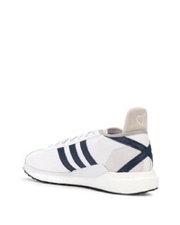 weiße und dunkelblaue Sportschuhe von adidas