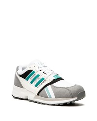 weiße und grüne Sportschuhe von adidas