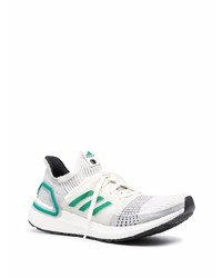 weiße und grüne Sportschuhe von adidas